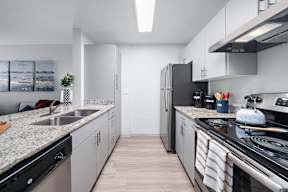 A modern kitchen with a black fridge and stove top oven.