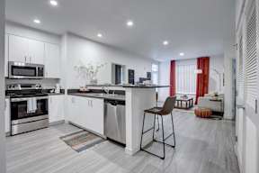 A modern kitchen with a bar stool in front of it.