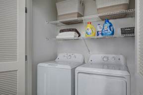 Two white washing machines in a laundry room.