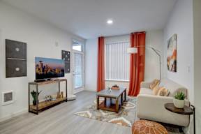 A living room with a couch, a coffee table, and a TV.