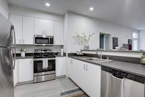 A modern kitchen with stainless steel appliances and white cabinets.