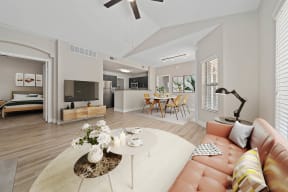 Furnished model unit living room with a couch and a table,ceiling fan, large windows