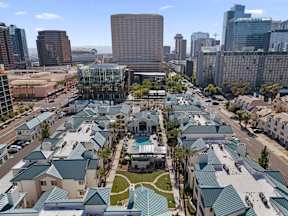 A view of a city with a lot of buildings and a green roofed building in the foreground.