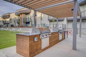 A patio with a barbecue grill and a table with chairs