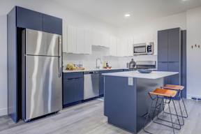 A modern kitchen with a large island and stainless steel appliances.