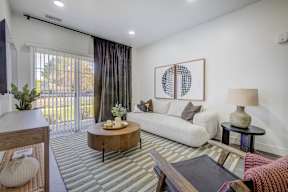 A living room with a white couch, a coffee table, and a painting on the wall.