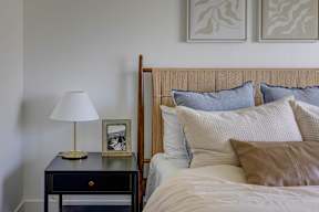 A bed with a white comforter and a brown pillow is in the foreground of the image.