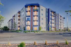 A modern apartment building with a mix of stone and panel exterior.