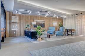 A modern living room with a blue sofa and a wooden cabinet.