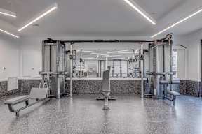 a gym with equipment and mirrors in a building