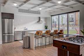 A modern kitchen with a bar area and a view of the backyard.