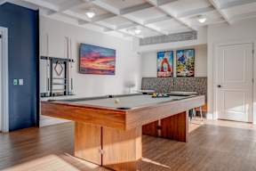 A pool table in a room with a blue wall and a white door.