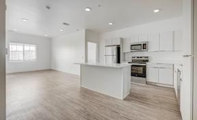 an empty kitchen with white cabinets and a white counter top