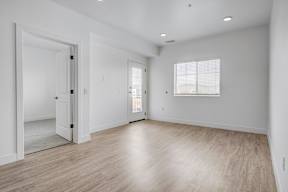 an empty living room with white walls and wood floors