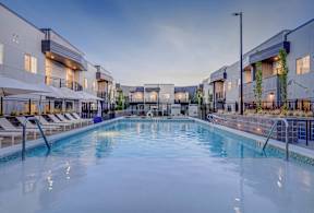 A large indoor swimming pool with lounge chairs and umbrellas.