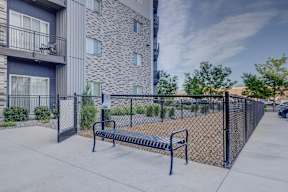 A black fence surrounds a concrete bench.