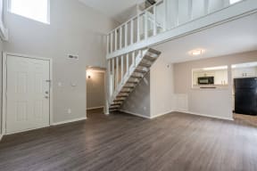an empty living room with a staircase in the middle