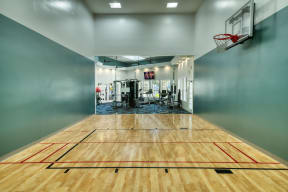 the court in the gym with a basketball hoop and a scoreboard