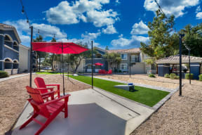 a red picnic table with a red umbrella and red chairs
