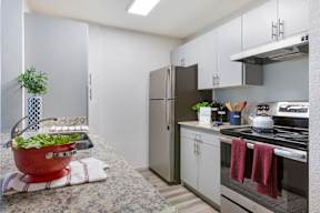 A kitchen with a red colander on the counter.
