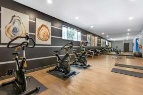 A gym with exercise bikes and yoga mats.