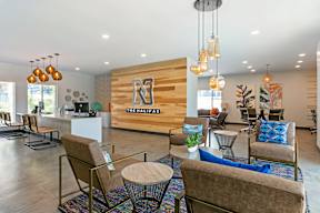 A modern waiting room with a wooden wall and comfortable seating.