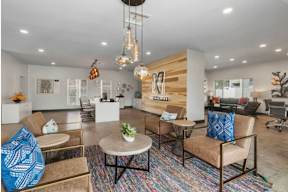 A modern living room with a wooden accent wall and a variety of seating options.