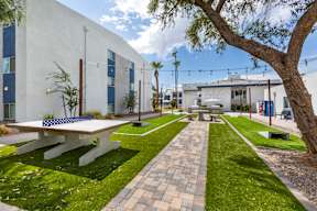 A white building with a blue bench in front of it.