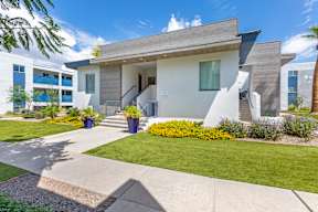 A modern house with a white exterior and a grey roof.