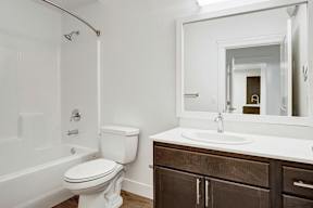 A white toilet sits next to a white sink in a bathroom.