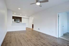 A room with a ceiling fan and wooden flooring.