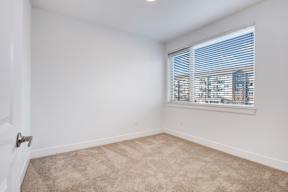 A room with a window and a carpeted floor.