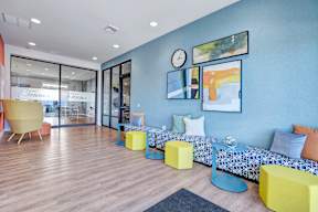 A brightly colored room with a blue wall and a sofa with a patterned cushion.
