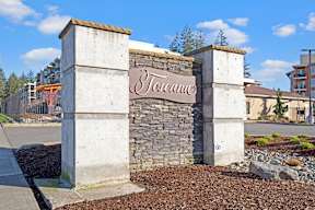 A stone wall with a sign that says