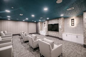 A room with a row of chairs and a television on the wall.