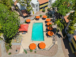 Areal view of the pool deck with orange umbrellas at the best apartments in Tempe, AZ.