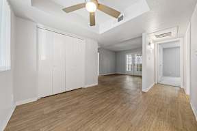 a bedroom with a ceiling fan and a closet