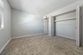 a bedroom with an open doorway and carpeted flooring