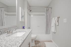 Bathroom with granite countertop and shower/tub combo with curved shower rod  at Vista Commons Apartments, South Carolina, 29201