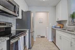 Model kitchen white cabinets, granite, stainless steel appliances  at Vista Commons Apartments, Columbia, SC