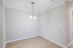 A room with a wooden floor and a light fixture hanging from the ceiling.