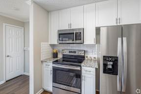 A kitchen with white cabinets and stainless steel appliances.