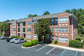 A parking lot in front of a red brick building.