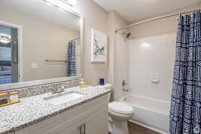 A bathroom with a white toilet, a sink, and a shower.