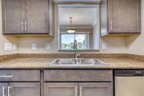 A kitchen with a granite countertop and stainless steel appliances.