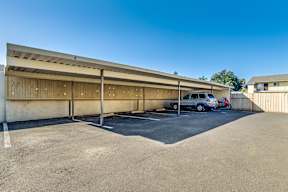 A parking lot with a building and a car.