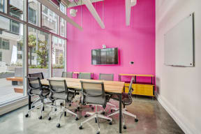 a conference room with a pink wall and a table with chairs at L Seven, San Francisco, California 94103