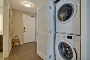 a washer and dryer in a laundry room with a white door at L Seven, San Francisco, California 94103