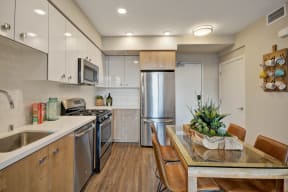a kitchen with stainless steel appliances and a table with chairs at L Seven, California
