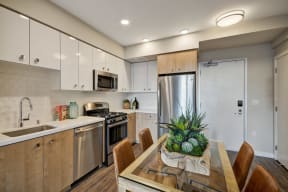 a kitchen with stainless steel appliances and a table with chairs at L Seven, San Francisco